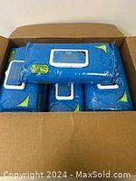 Top view of a cardboard box open containing 5 blue packages of Hygea washcloths
