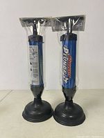 Two new Power Plunge-It air powered plungers side by side, sealed in plastic packaging
