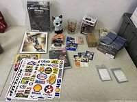 Photo of the entire lot showing collectibles including toys, cards, stickers, glass, artworks.