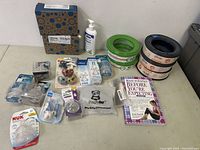 Photo of various new baby items arranged on a table including pacifiers, baby bottles, teethers, baby food containers, lotion, and a pregnancy book.