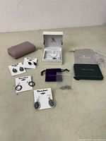 Wide view of costume jewelry lot with earrings, pendant necklace box, small pouch and wallet case