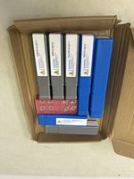 Top view showing seven lathe threading tools in two colors of plastic cases inside an open cardboard box.