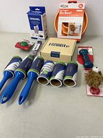 Photo showing grooming brushes, lint rollers, pet remote box, orange slow feeder bowl, and plush chew toy