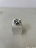 Front view of the silver ring showing the cluster of blue stones on top.