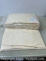 View of cream-colored fitted sheets in original sealed packaging