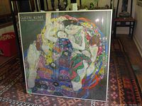 Front view of framed Gustav Klimt poster on floor showing full artwork and frame