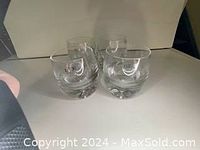Four clear glass Swedish tumblers grouped together showing the solid base and round form at the top