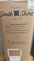 Cardboard box showing South Shore Furniture brand and logo, indicating furniture inside.