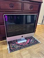 Apple iMac 2009 model desktop computer with aluminum frame on stand, powered off, front view.