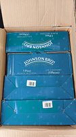Photo of four sealed boxes of Johnson Bros 5 Piece Place Settings in an open cardboard box.