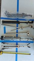 Photo showing various metal stands and components laid out, including mic stands, cymbal stand parts, and guitar stand parts.