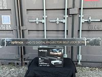 Wide view showing both projector box and long screen box on table