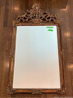 Full front view of the rectangular mirror showing entire gilt frame and beveled glass