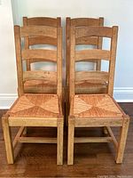 Two chairs front view showing ladder back and rattan seats