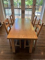 Three-quarter front view showing table top surface and four matching chairs