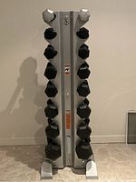 Front view of silver dumbbell rack loaded with black hex dumbbells