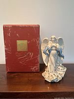 Angel of Hope porcelain figurine shown next to original red Lenox box with gold label, displaying overall condition and packaging.