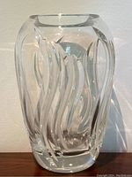Front view of clear heavy crystal vase showing etched flame-like design and smooth oval shape.