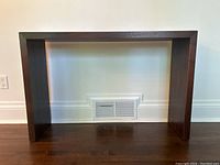 Front view of a solid wood console table with minimalist design and dark stain.