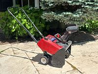 Side angle of the Toro snowblower showing body, handle, and wheels.