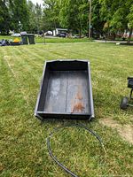 Top view of black metal cart showing rust and wear inside the tub section.