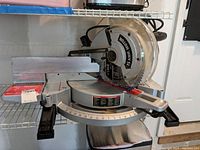 Side view of the saw showing blade, miter scale, and motor casing