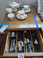 Photo showing Pfaltzgraff flatware organized in a drawer including forks, knives, spoons, and serving pieces.