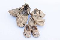 Three pairs of handmade straw shoes displayed together on a white background: closed shoes, baby shoe pair, and sandals.