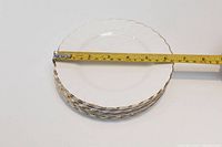 Side view of stacked plates with measuring tape showing approximately 6 1/4 inch diameter.