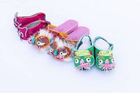 Front view of three pairs of brightly colored Chinese children's lion shoes arranged side by side