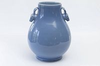 Front view of a blue glazed Chinese pear-shaped ceramic vase with deer head handles on neck.