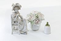 Porcelain items - seated female figurine, pot with porcelain roses, and Coalport bell