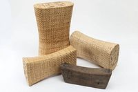 Four Chinese headrests displayed on a white background: one dark antique wooden piece and three light natural woven pieces of various sizes and shapes.