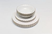 Image showing stacked Royal Albert Val D'Or white porcelain dishes including dessert bowls and plates of two sizes with gold trim.