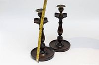 Pair of turned wood candle holders shown with measuring tape indicating height of about 12 inches.