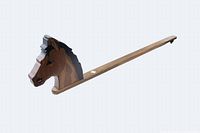 Front side view of the wooden horse head attached to a long plank, showing detailed hand painted features including eyes, mane, and nostrils.