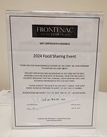 Frontenac Club gift certificate printed on white paper in plastic stand showing certificate number, event title and terms