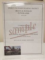 Printed sign displaying voucher details, value, and donor information with business card pop-up