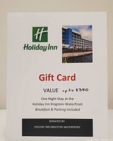 Printed voucher signage showing Holiday Inn logo, hotel photo, and gift card details