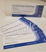 Five blue and white printed complimentary skate passes from Invista Centre arranged on a white background.