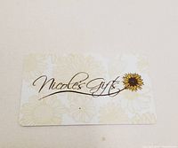 Photo of $100 Nicole's Gifts gift card, showing front with floral background and brand logo.