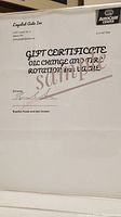 Photo of the gift certificate for oil change and tire rotation valued at $125 from Loyalist Auto Inc with signatures.