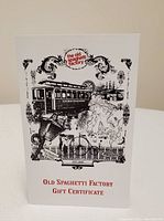 Photo of the gift certificate showing vintage-style illustrations and the Old Spaghetti Factory logo.