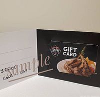 Photo showing the $75 One Eyed Jack Pub and Grill gift card in a black holder with food imagery and handwritten value and card number.