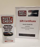 Gift certificate in plastic stand with Rust Check branding and informational brochure alongside