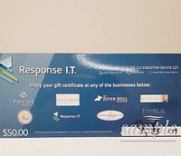 Photo of the $50 gift certificate card showing participating business logos and address.