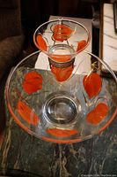 Top view of the orange leaf chip and dip bowl set showing the painted orange leaf design on clear glass.