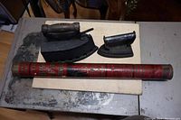 Photo showing two antique sad irons (one large coal iron and one smaller C-Star iron) alongside a vintage cylindrical Bickle Seagrave fire extinguisher.