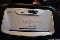 Close-up of control panel showing Staples logo, switch, safety icons, and shredder slot.