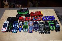 Photo showing all 17 toy cars including 14 Hot Wheels cars and 3 additional toy cars. Variety of colors and designs including monster trucks, race cars, and classic cars.